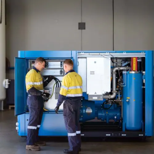 Técnicos em atendimento a um compressor de parafuso