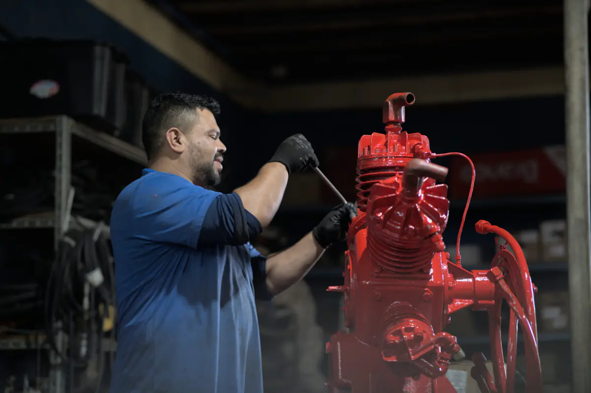 Técnico da Real Compressores fazendo manutenção em compressor de ar